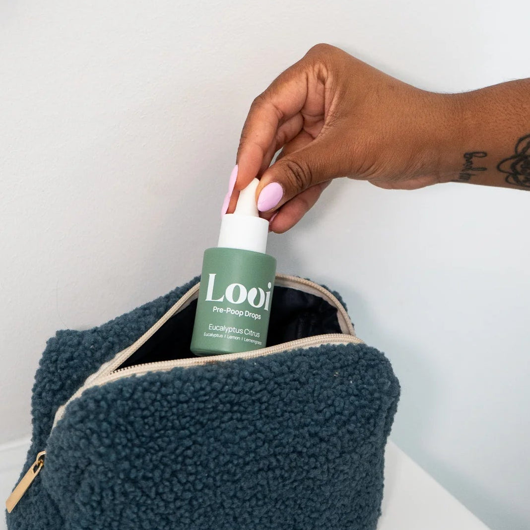 Person placing a bottle labeled 'Loui' into a textured teal pouch on a white surface.