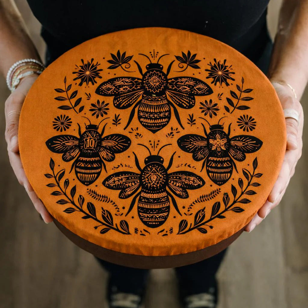 Person holding a large bowl with a golden bowl cover with a black bee print on it.
