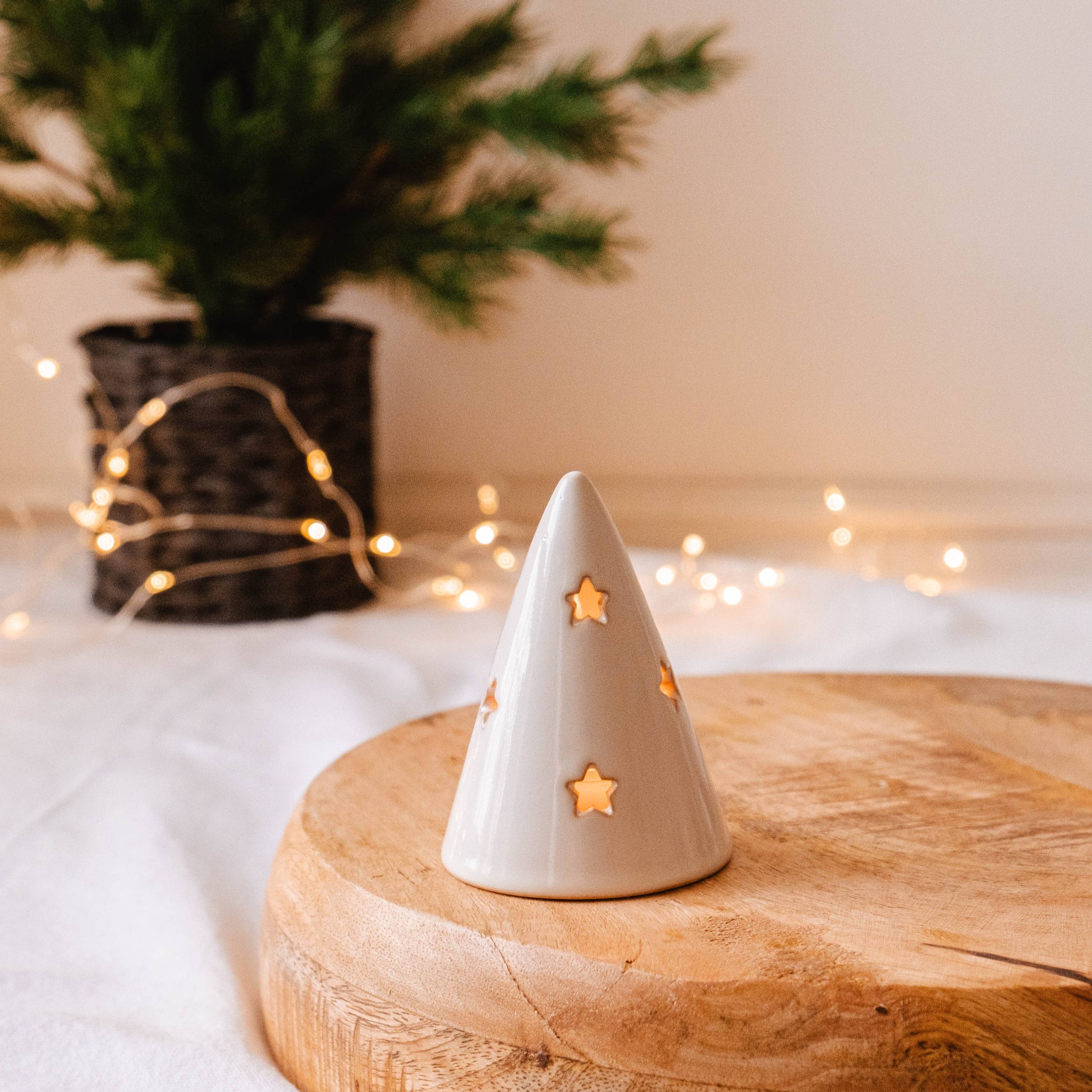 White ceramic cone with star holes on a wooden board with a soft, blurred background